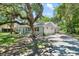 Charming single-story home featuring mature trees, lush green lawn and a paved driveway at 4901 Sailfish Dr, Ponce Inlet, FL 32127