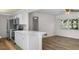Open kitchen boasts white cabinets, stainless steel appliances and light wood flooring at 4901 Sailfish Dr, Ponce Inlet, FL 32127