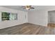 Bright living room featuring wood-look flooring, a ceiling fan, and a large entry door at 4901 Sailfish Dr, Ponce Inlet, FL 32127