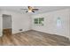 Bright living room featuring wood-look flooring, a ceiling fan, and a large entry door at 4901 Sailfish Dr, Ponce Inlet, FL 32127