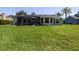Large, lush backyard featuring an enclosed patio area and a well-maintained lawn perfect for outdoor activities at 516 Spotted Sandpiper Dr, Daytona Beach, FL 32119