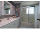 Coastal bathroom with a wood plank wall, decorative mirror, and a shower-tub with sliding glass doors at 516 Spotted Sandpiper Dr, Daytona Beach, FL 32119