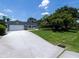 Exterior view of this house with a sprawling driveway and mature trees at 516 Spotted Sandpiper Dr, Daytona Beach, FL 32119