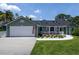 Charming single-story home with a spacious driveway, two-car garage, and a quaint front porch at 516 Spotted Sandpiper Dr, Daytona Beach, FL 32119