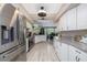 Open kitchen with white cabinets, stainless appliances, granite counters and a dining area at 516 Spotted Sandpiper Dr, Daytona Beach, FL 32119