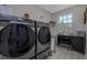 Laundry room featuring modern Samsung washer and dryer, desk with sewing machine, and bright natural light at 516 Spotted Sandpiper Dr, Daytona Beach, FL 32119