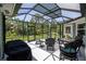 Enclosed patio featuring outdoor seating and views of the manicured backyard at 516 Spotted Sandpiper Dr, Daytona Beach, FL 32119
