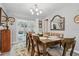 Dining room with a wooden table set for six, view to outdoor patio at 934 Tall Pine Dr, Port Orange, FL 32127