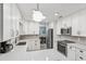 Well-lit kitchen featuring white cabinetry, stainless steel appliances, and gray backsplash at 934 Tall Pine Dr, Port Orange, FL 32127