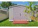 Exterior of a modern garden shed with double doors and vibrant green lawn at 934 Tall Pine Dr, Port Orange, FL 32127