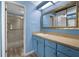 Traditional bathroom features blue vanity with granite counters and enclosed shower at 1 Tomoka Oaks Blvd # 135, Ormond Beach, FL 32174