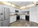 Modern kitchen featuring stainless steel appliances, white cabinets and updated wood grain flooring at 1 Tomoka Oaks Blvd # 135, Ormond Beach, FL 32174