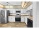 Well-lit kitchen featuring stainless steel appliances, white cabinetry and wood grain flooring at 1 Tomoka Oaks Blvd # 135, Ormond Beach, FL 32174