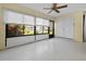 Bright sun room with a ceiling fan and sliding windows overlooking the yard at 1 Tomoka Oaks Blvd # 135, Ormond Beach, FL 32174