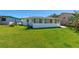 The fully fenced backyard features green grass and an enclosed patio providing privacy and space for recreation at 129 Dundee Rd, Daytona Beach, FL 32118