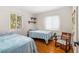 Comfortable bedroom featuring hardwood floors, natural light and a cozy rocking chair at 129 Dundee Rd, Daytona Beach, FL 32118