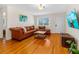 Comfortable living room showcasing hardwood floors, a leather sofa, and a decorative houseplant at 129 Dundee Rd, Daytona Beach, FL 32118