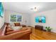 Inviting living room featuring a leather sofa, hardwood floors, and a mounted television at 129 Dundee Rd, Daytona Beach, FL 32118