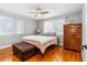 Main bedroom featuring hardwood floors, ceiling fan, natural light, and a leather ottoman at 129 Dundee Rd, Daytona Beach, FL 32118