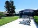 Private backyard with patio, hot tub, screened enclosure, and mature trees at 13 Sunrise Ave, Ormond Beach, FL 32176