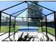 Backyard spa area features a covered hot tub, surrounded by a screened enclosure and lush greenery at 13 Sunrise Ave, Ormond Beach, FL 32176