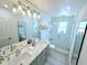 Elegant bathroom featuring double sinks, modern fixtures, and a spacious glass-enclosed shower at 13 Sunrise Ave, Ormond Beach, FL 32176