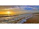 Serene beach view with gentle waves and golden sunlight at 13 Sunrise Ave, Ormond Beach, FL 32176