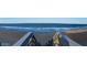 Breathtaking panoramic beach view with rolling waves, wooden staircase, and blue skies at 13 Sunrise Ave, Ormond Beach, FL 32176