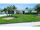 Well-maintained home with lush green lawn, mature palm trees, and a charming front porch at 13 Sunrise Ave, Ormond Beach, FL 32176