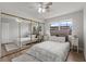 Bedroom with mirrored closet doors, ceiling fan and light, neutral walls, and wood laminate flooring at 136 Reef Rd, South Daytona, FL 32119