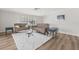 Bright living room featuring hardwood floors, neutral furniture, and light-filled shuttered windows at 136 Reef Rd, South Daytona, FL 32119