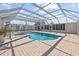 Backyard pool with attached spa, surrounded by a screened enclosure and a paved patio area at 136 Reef Rd, South Daytona, FL 32119