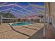 Fully enclosed backyard pool and jacuzzi featuring brick pavers, tropical vegetation, and lots of space at 136 Reef Rd, South Daytona, FL 32119