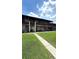 Two-story condo building with screen patios, a spiral staircase, and a manicured lawn at 1640 Juno Trl # 202E, Astor, FL 32102