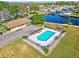 An aerial view of a fenced in community pool surrounded by lush green grass and trees at 1640 Juno Trl # 202E, Astor, FL 32102