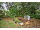 The backyard features a raised-bed garden and a potting bench surrounded by mature trees at 2101 Almond St, Orange City, FL 32763
