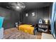 A cozy bedroom boasts dark walls, wooden floors, and natural light from a window at 2101 Almond St, Orange City, FL 32763