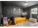 A cozy bedroom boasts dark walls, wooden floors, and natural light from a window at 2101 Almond St, Orange City, FL 32763