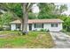 Charming single-story home with a white brick exterior, well-maintained lawn, and mature shade trees at 2101 Almond St, Orange City, FL 32763