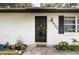 Close-up of front door of home with potted plants and decorative tile walkway at 2101 Almond St, Orange City, FL 32763