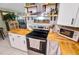 A kitchen featuring stainless steel appliances, white cabinets, butcher block countertops and decorative shelving at 2101 Almond St, Orange City, FL 32763