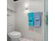 Bathroom featuring a white toilet, glass shelving, and neatly hung blue towels for a fresh look at 2934 Oceans Trce, Daytona Beach Shores, FL 32118