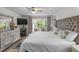 Comfortable main bedroom with a plush upholstered headboard, bay window, dresser, and soft lighting at 2934 Oceans Trce, Daytona Beach Shores, FL 32118