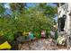 Outdoor patio with tiled floor, wicker furniture, colorful cushions, and lush foliage surrounding the seating area at 2934 Oceans Trce, Daytona Beach Shores, FL 32118