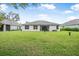 Rear exterior view of the house with a spacious backyard and well-maintained lawn at 3029 Adrian Dr, Ormond Beach, FL 32174
