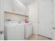 Neat laundry room with a washer, dryer, overhead cabinets, and wood-look tile flooring at 3029 Adrian Dr, Ormond Beach, FL 32174