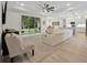 Open concept living room featuring a plush white sectional, large windows, and tray ceilings at 3029 Adrian Dr, Ormond Beach, FL 32174