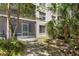 A condo backyard shows a screened in patio, palm trees and other attractive landscaping at 640 N Nova Rd # 117, Ormond Beach, FL 32174