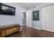 Bedroom with a flat screen tv, hardwood floors, closet, and an ornate wooden chest at 640 N Nova Rd # 117, Ormond Beach, FL 32174