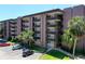 Exterior shot of condominium with parking, landscaping, and multi-story covered balconies at 640 N Nova Rd # 117, Ormond Beach, FL 32174